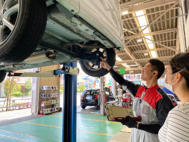整備工場で車を確認するスタッフ